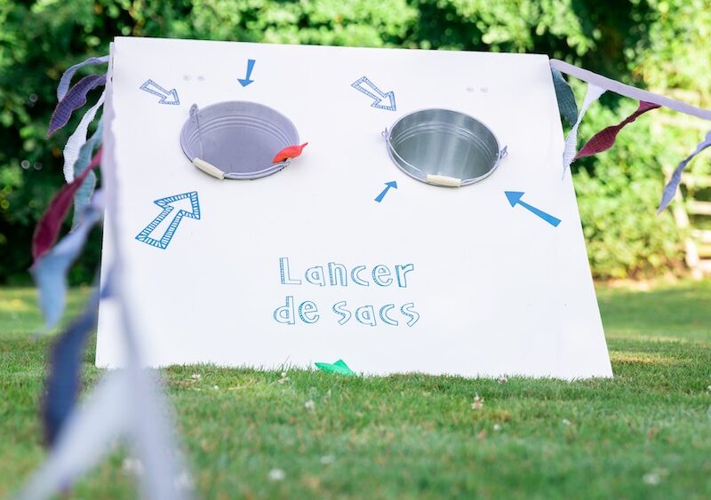 Jeu de lancer de sacs géant en bois avec ligne de départ et drapeau guinguette à louer pour les événements, les mariages, les anniversaires, les soirées, les séminaires