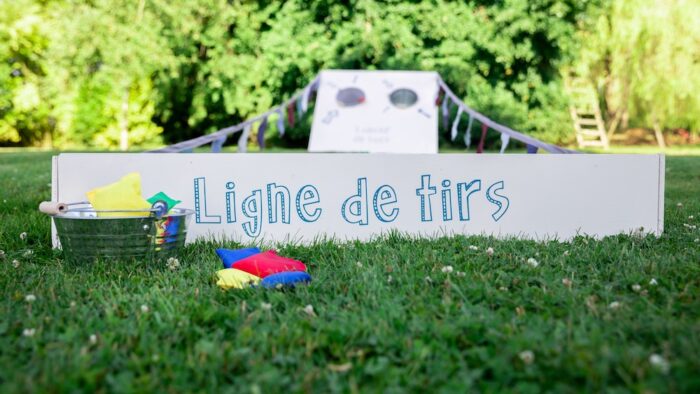 Jeu de lancer de sacs géant en bois avec ligne de départ et drapeau guinguette à louer pour les événements, les mariages, les anniversaires, les soirées, les séminaires